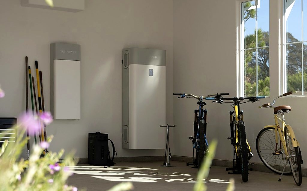 SunPower SunVault battery storage units installed in a residential garage with bikes and garden tools visible